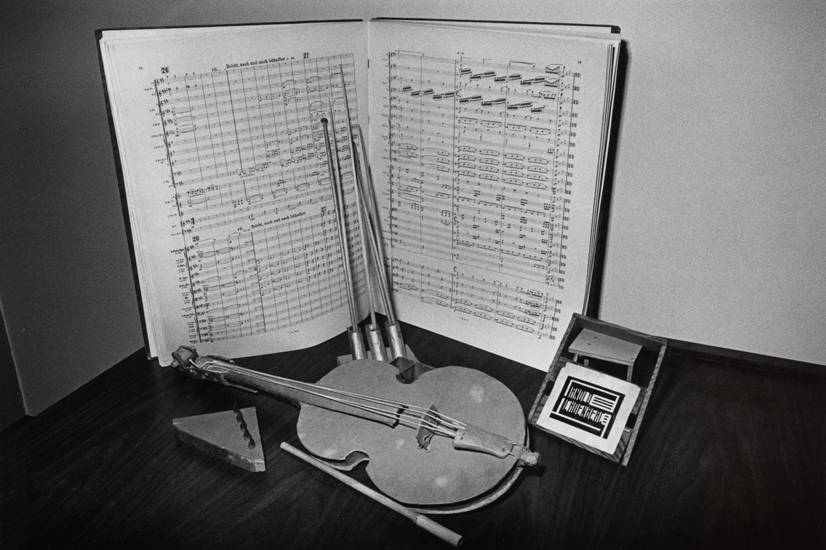 Partitura Písní z Gurre obklopená artefakty z dílny Arnolda Schönberga, mj. originálními krabičkami z odpadového papíru lepeného do vrstev. Jedna z nich má tvar houslí